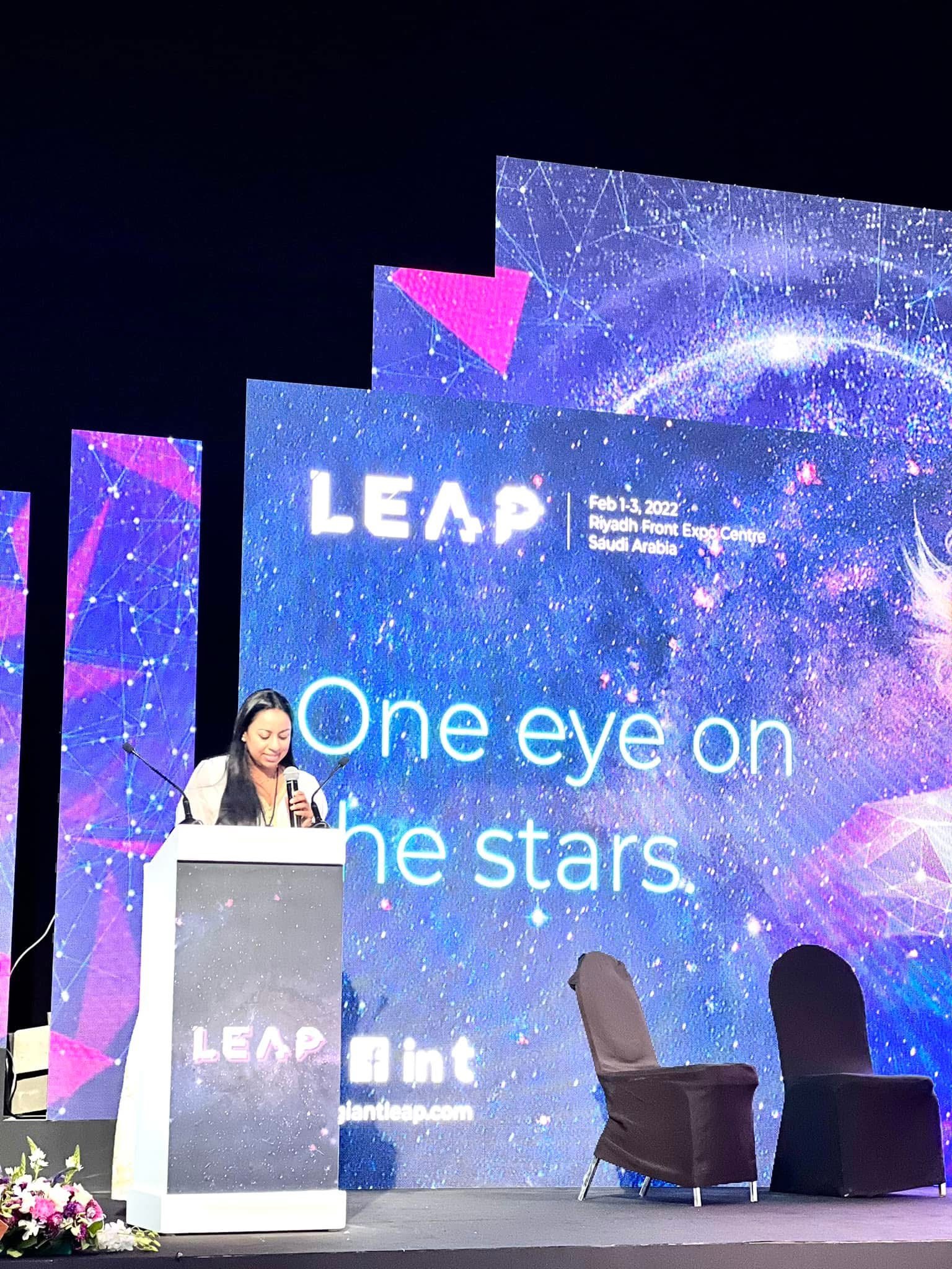 Anu Bhardwaj at the podium on the main LEAP stage — delivering her keynote "SHEQONOMI: Digital Inclusion, Investing, and a She-Economy Powered by Women & Girls" · LEAP Summit, Riyadh Front Expo Centre, February 2022