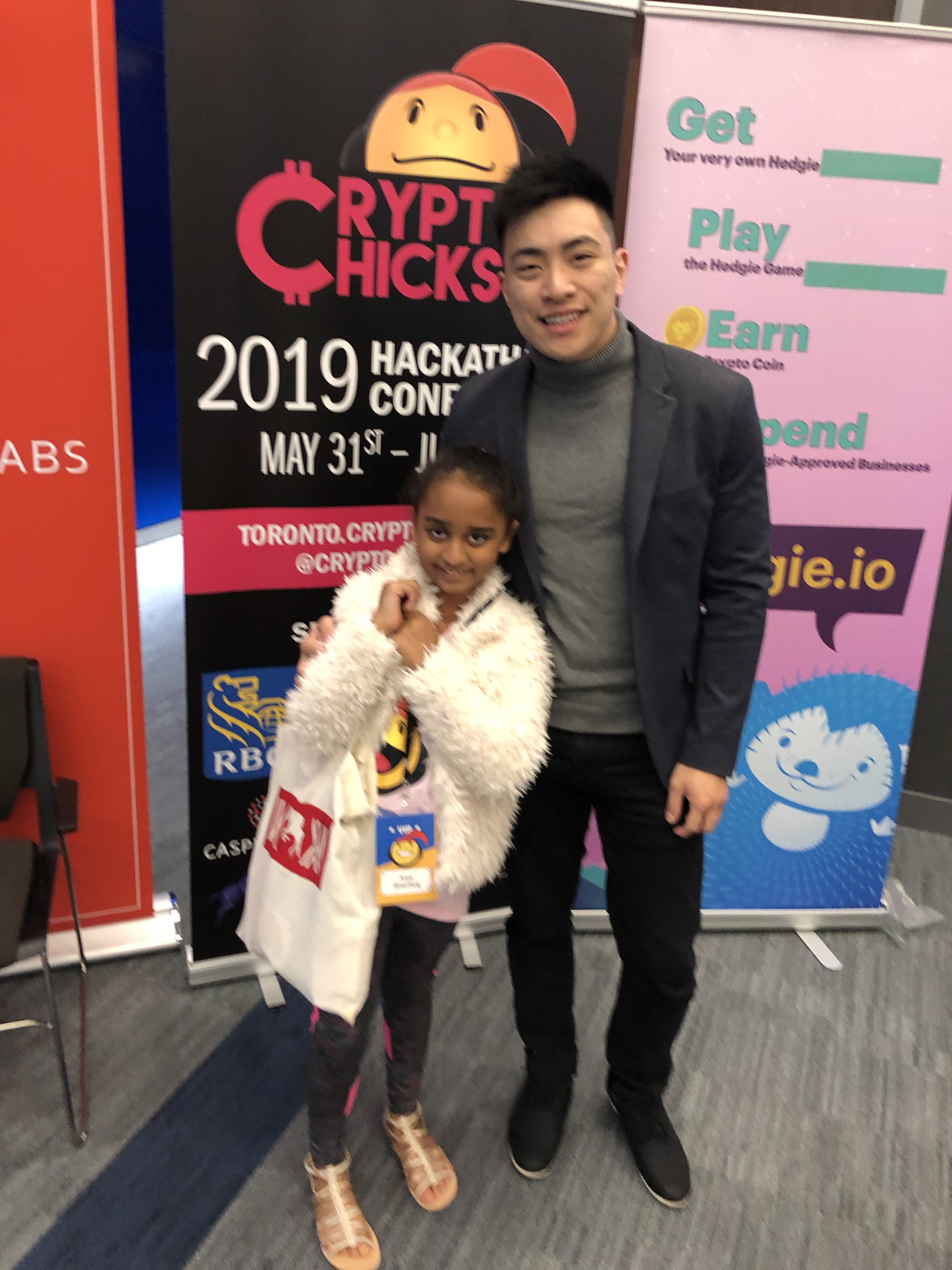 Arya Bhardwaj with Dr. Nataliya Hearn — Co-Founder, CryptoChicks — in front of the CryptoChicks 2019 Hackathon + Conference banner · May 31–June 2, Toronto